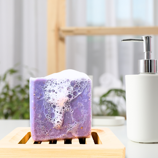 Lifestyle shot of Sudsverse Lavender Oatmeal soap on a bamboo soap dish showing the rich and creamy lather of the natural handmade soap.
