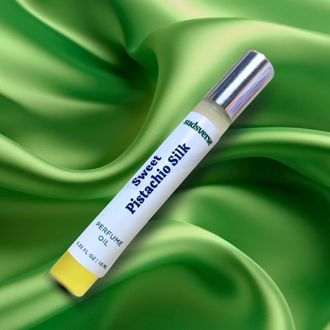 Perfume oil bottle labeled 'Sweet Pistachio Silk' on a green fabric background