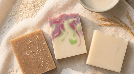 Three handcrafted rice milk soap bars arranged together with natural ingredients like rice, oats, and botanicals, showcasing Sudsverse®’s hydrating cold process collection.