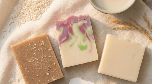 Three handcrafted rice milk soap bars arranged together with natural ingredients like rice, oats, and botanicals, showcasing Sudsverse®’s hydrating cold process collection.