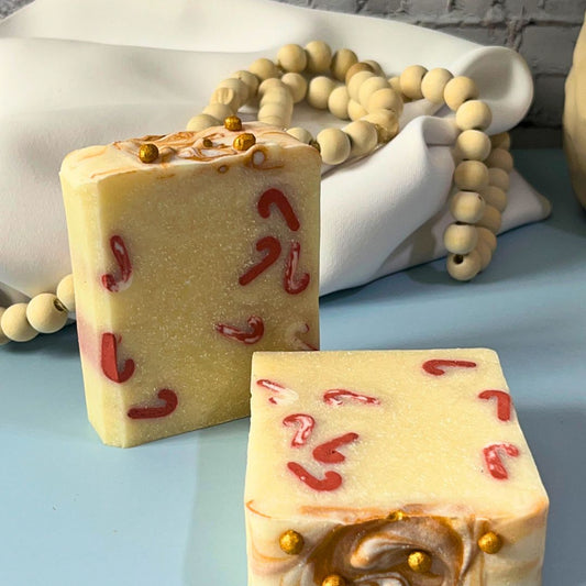 Handmade plant-based candy cane soap bar featuring festive red candy cane designs on creamy base