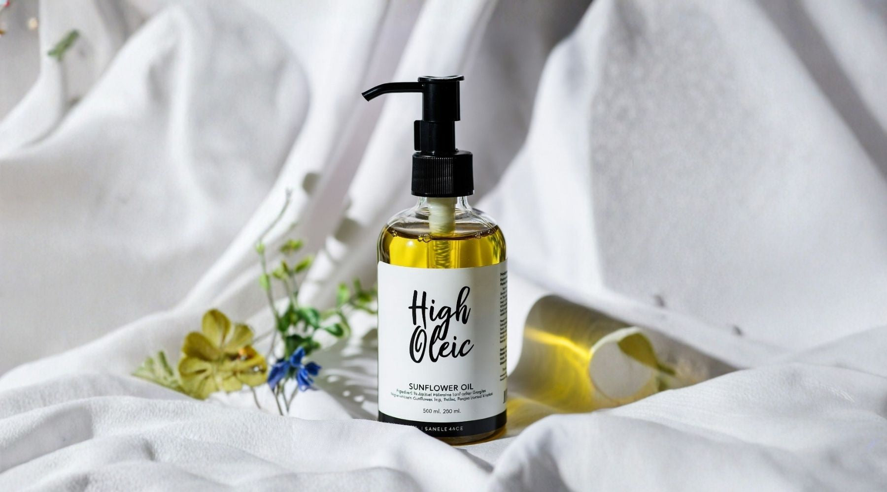Bottle of High Oleic sunflower oil on a white fabric background with flowers.
