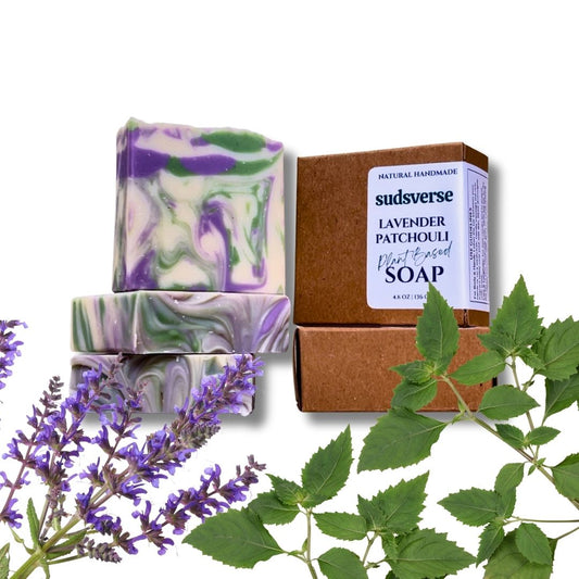 Handmade soap bars with a box labeled 'sudsverse' surrounded by lavender flowers and leaves on a white background.
